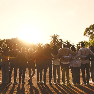 Group of people embracing at sunset