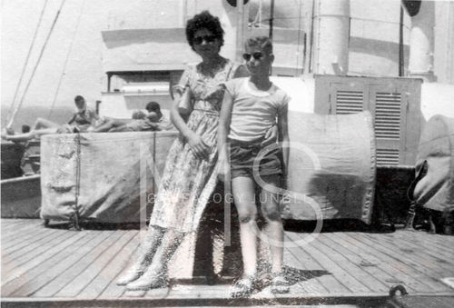 Black and white photo: Woman and boy on ship deck