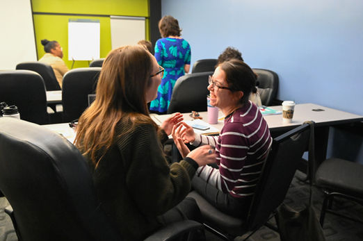 Two people are facing each other and laughing.