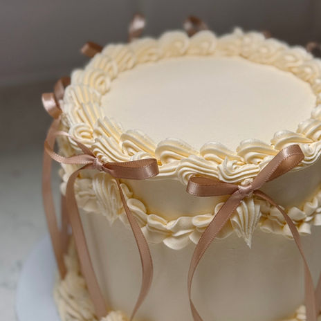 Close-up of Lambeth piping detail  and champagne bows on celebration cake