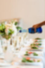 Wedding coordinator pouring champagne at a well-set table for the guests