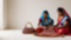 Create an image of two women making a kauna bag while wearing traditional Indian dresses,