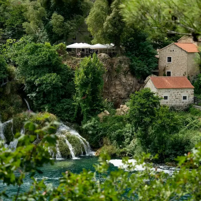 Historic stone houses near the waterfalls inside Krka National Park on a personalized tour.