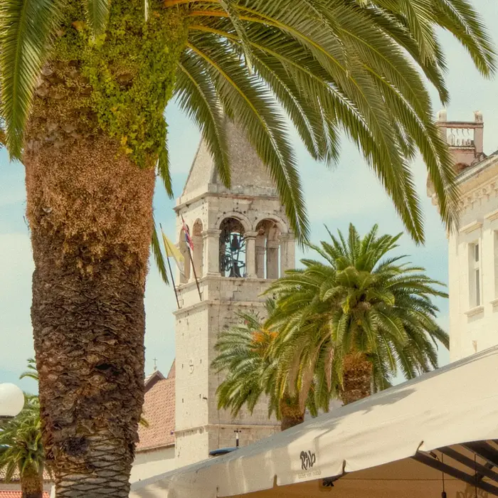 Luxury private car service drop-off at the historic Trogir waterfront promenade.