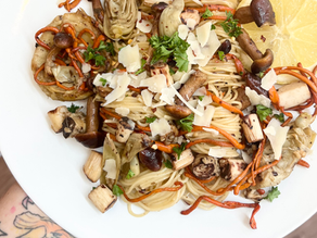 A bowl of plant-based pasta with mushrooms and vegetables, illustrating a vegan meal option.