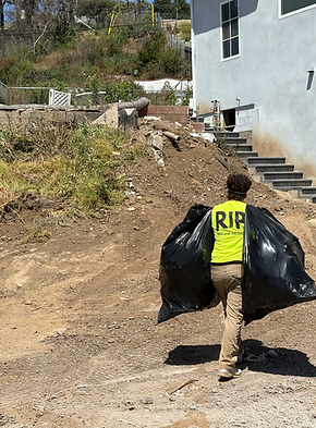 RIP volunteer carrying a bag of invasive vegetation removed from a fire affected residential property in Pacific Palisades.