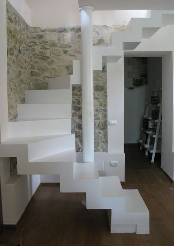 Scala interna moderna in resina bianca con pavimento in legno, affiancata da una parete in pietra naturale, situata in una casa a Brescia.