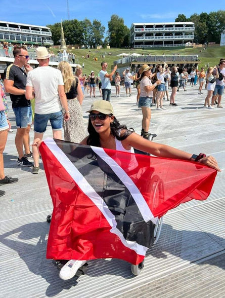 Mitera Balkaran holding a flag of Trinidad & Tobago