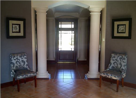 Elegant interior space with columns, chairs, and framed art