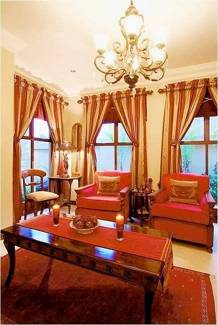 Elegant living space with red armchairs and chandelier