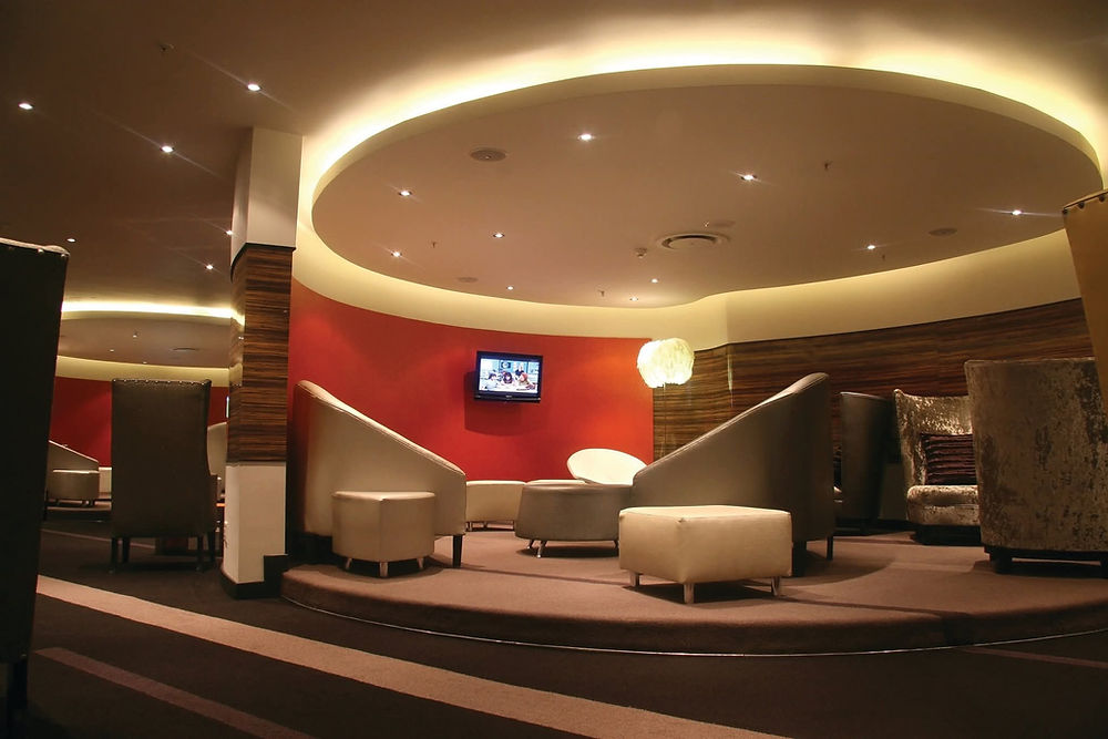 Stylish lounge space with circular lighting, red wall.