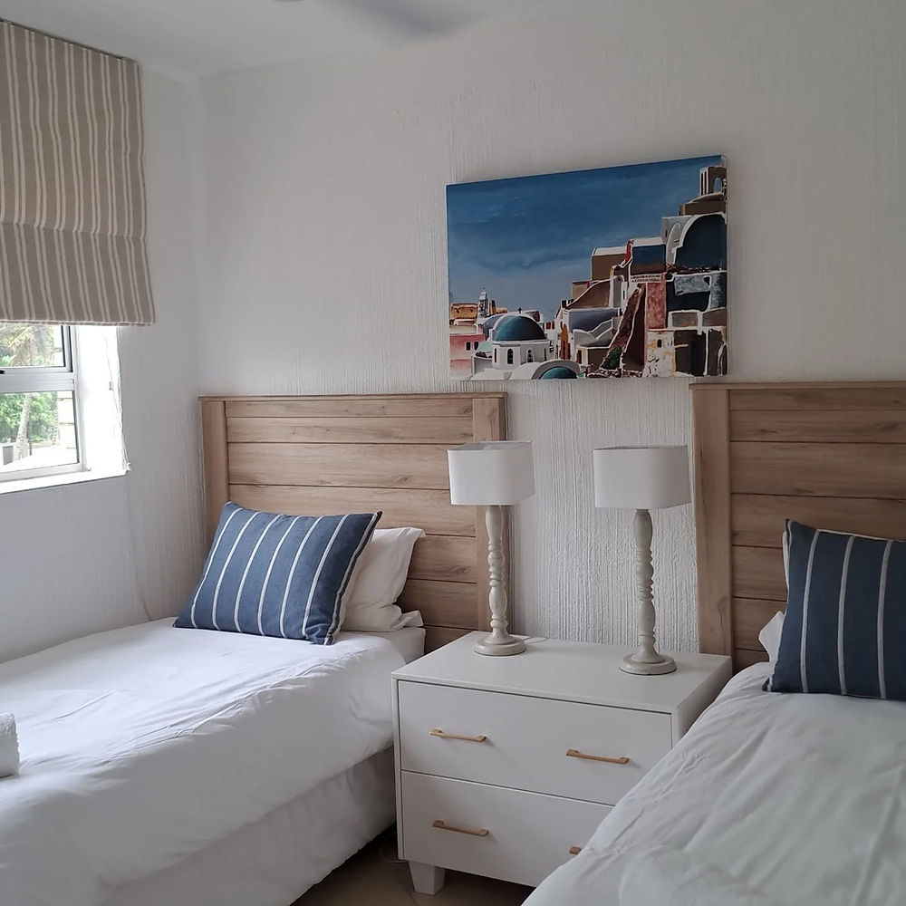 Twin bedroom space with two beds and a painting