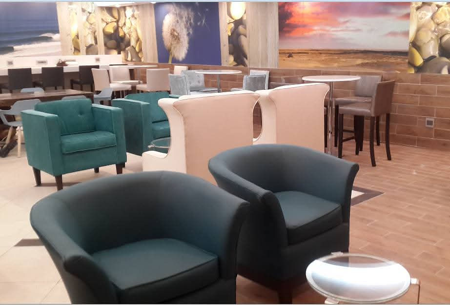 Lounge space with teal armchairs and various seating.