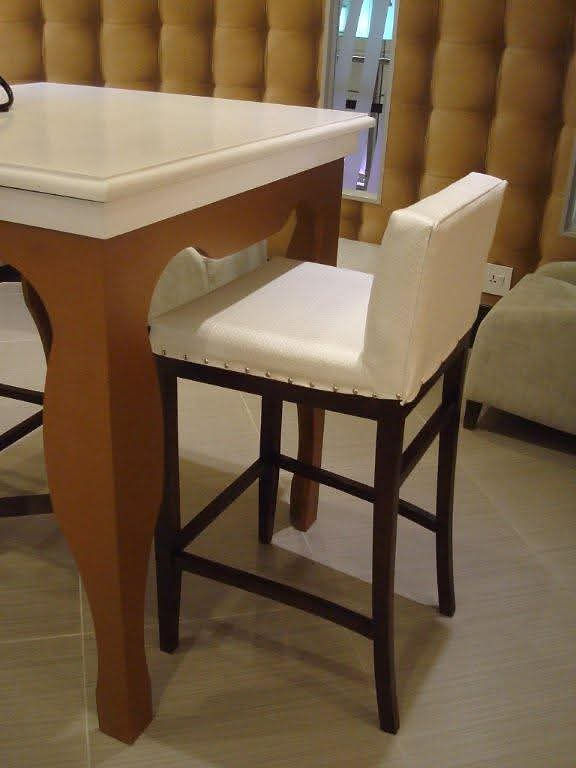 White bar stool next to a wooden table in a stylish space