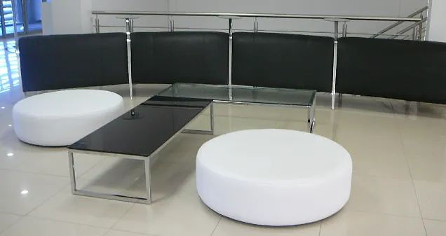 Modern lounge space with white ottomans and black tables