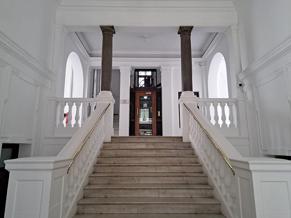 Grand staircase with dark pillars in an interior space.