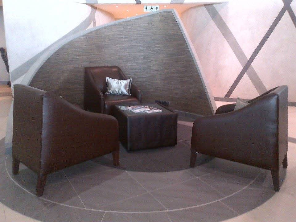 Lounge space with three brown armchairs and coffee table