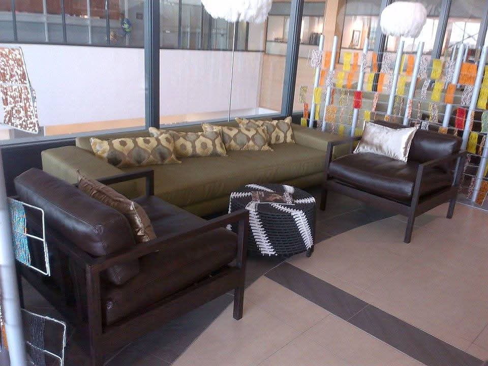 Modern lounge space with olive sofa and brown leather chairs