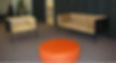 Modern armchair, sofa, and orange ottoman in commercial space