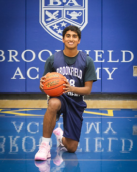 Young basketball player holding a trophy at youth basketball academy event