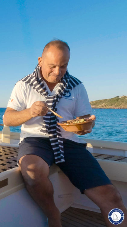 Il comandante Gianluca Perdisci assaggia il pranzo a bordo durante l'escursione in barca nel Sud Sardegna