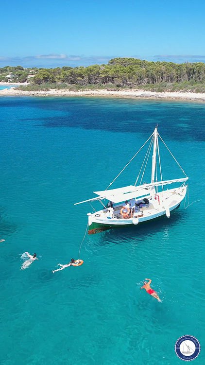 Durante l'escursione in barca in Sardegna, i passeggeri nuotano nel mare di Carloforte, nel Sulcis