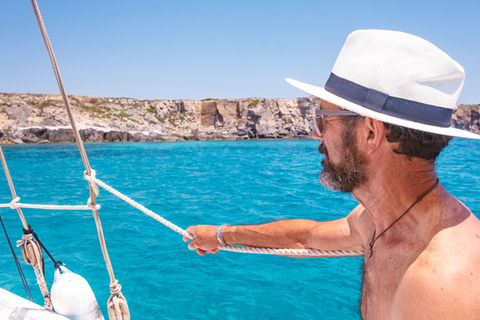 Passeggero che osserva la scogliera di Carloforte durante una escursione in barca nel Sud Sardegna