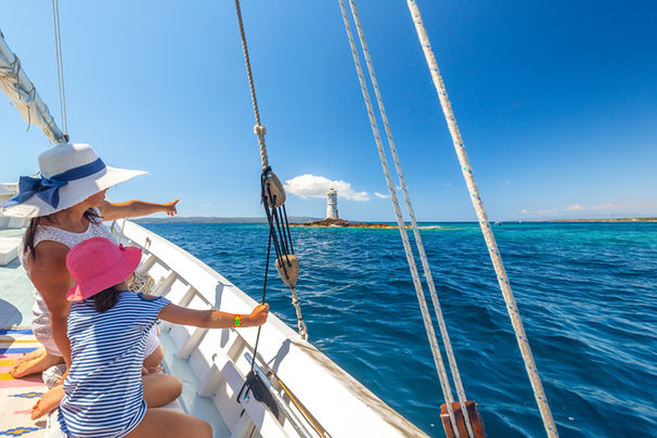 Passeggeri in vista al faro Mangiabarche di Calasetta durante una escursione in barca organizzata da Escursioni Barca Carloforte Sardegna