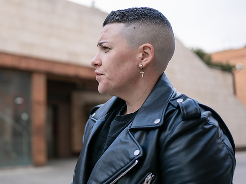 Person sitting on bench in city wearing leather jacket