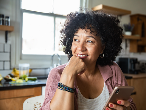 Woman sitting in kitchen on phone