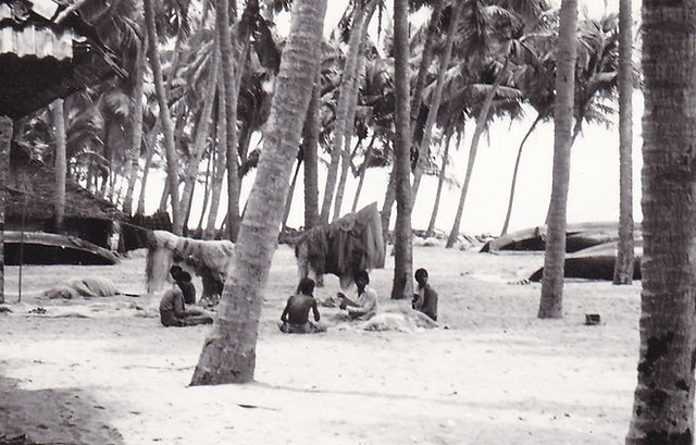 Fisherman winding their nets. Near upturned canoes. Ara Karapurram beach, Kerala. 01 Nov 1987