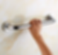 Hand testing grab bar stability showing early signs of loose grab bar and need for repair