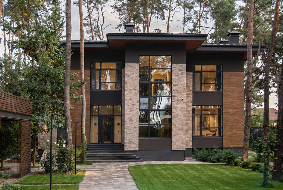 Front elevation view showing the mansion’s balanced composition, tall glass openings, natural stone, wood cladding, and evening atmosphere.