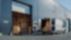 Outside of Logistics Warehouse with Open Door, Delivery Van Loaded with Cardboard Boxes. T