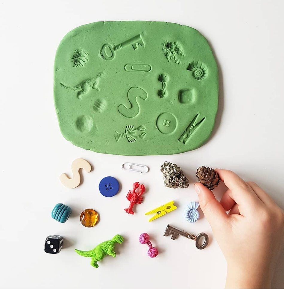 Puzzle made from various textural objects pressed into green playdough