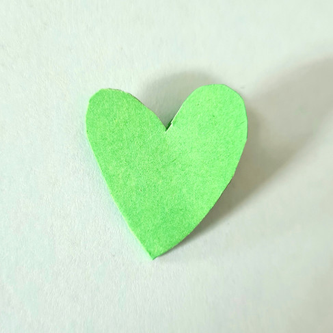 green paper cut into a heart shape