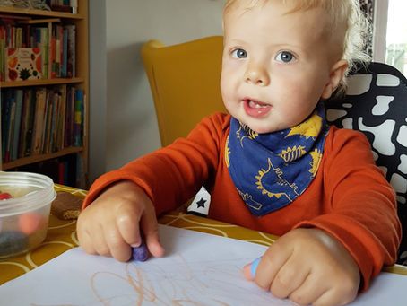 Toddler getting creative with some crayons