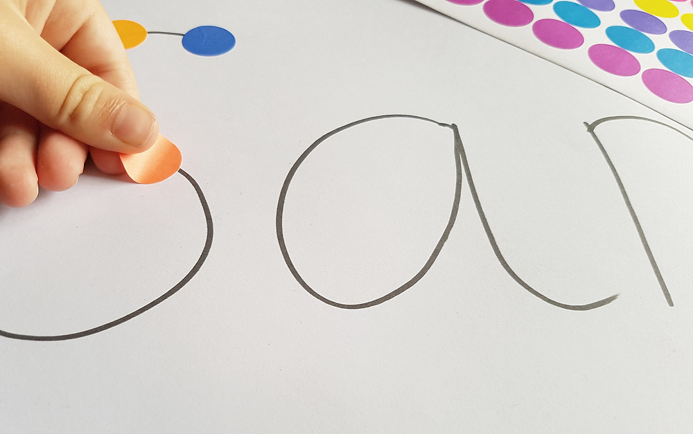 child learning names with dot stickers