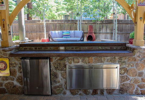 Custom outdoor kitchen with poured concrete countertops and stone veneer