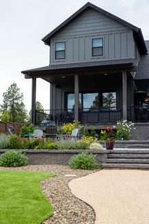 Multi-level backyard landscape with retaining walls, outdoor living areas, and family-friendly design in Northern Arizona.