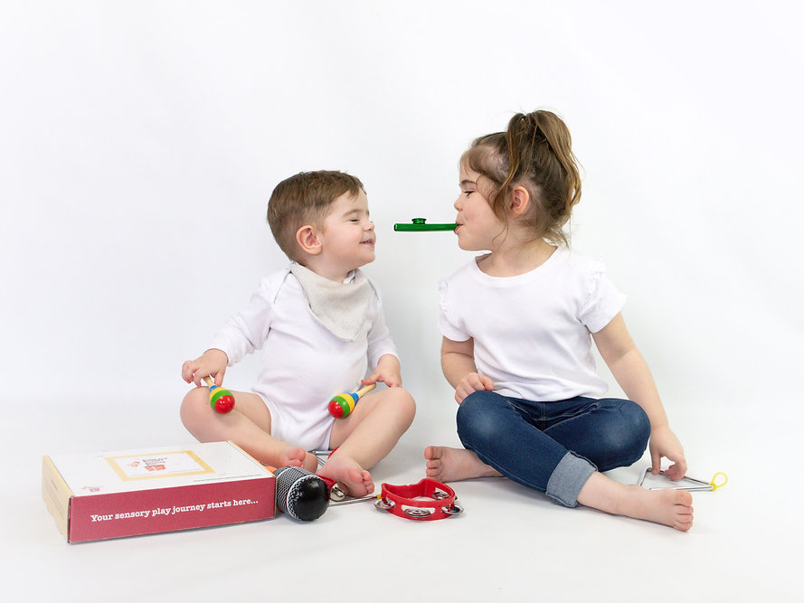 Two toddlers playing with sensory toy box