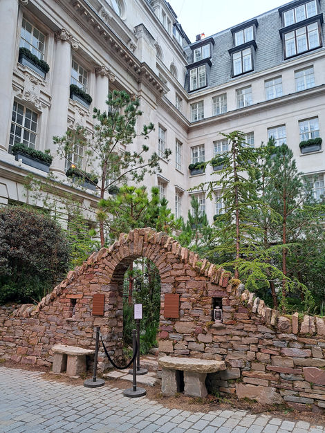 a stone archway in front of the Rosewood hotel in London