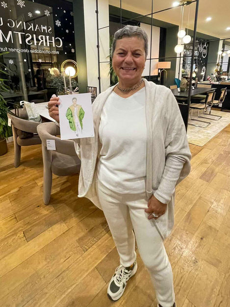 a woman holding a drawing of a woman in a green coat