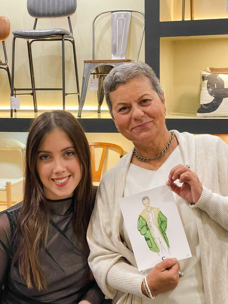 a woman is holding a drawing of a woman in a green coat