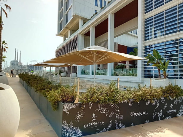 Para-sols grans de color clar donant ombra a terrassa de restaurant al passeig marítim de la Costa Brava