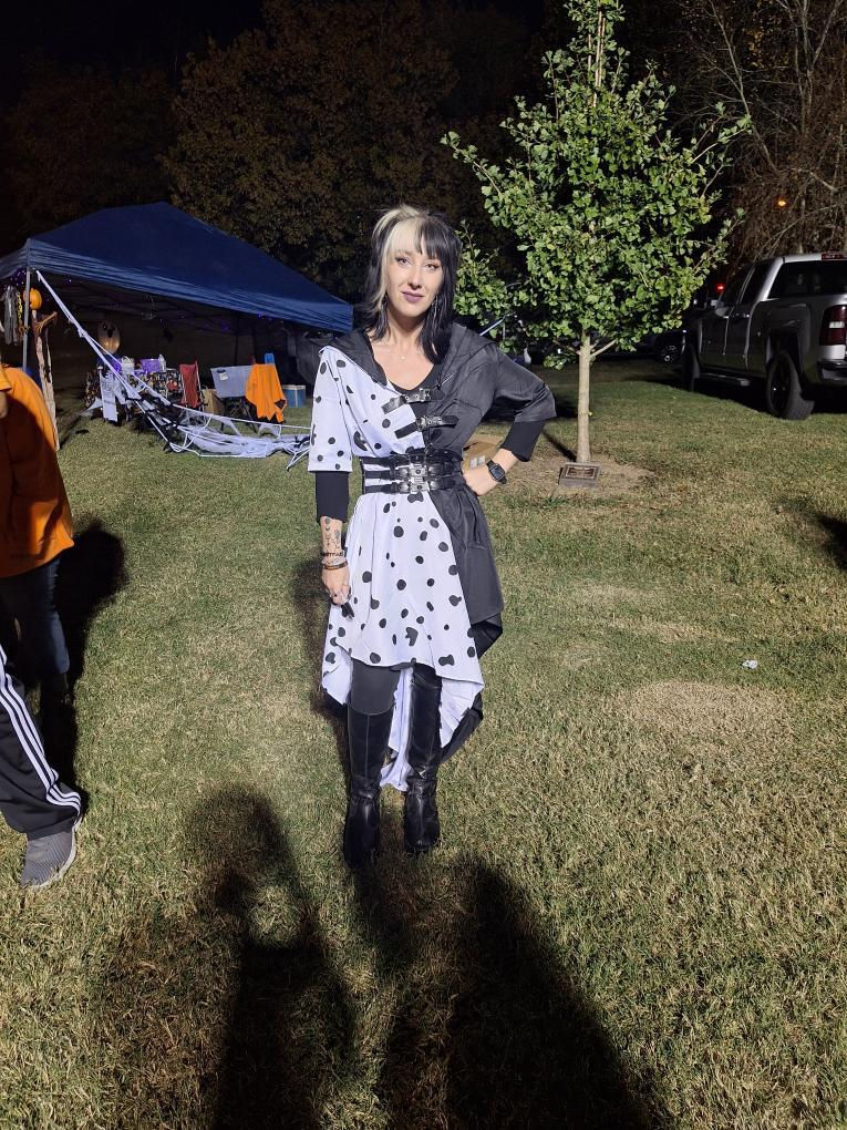 A lady in a costume, adorned with dalmation spots on the side.