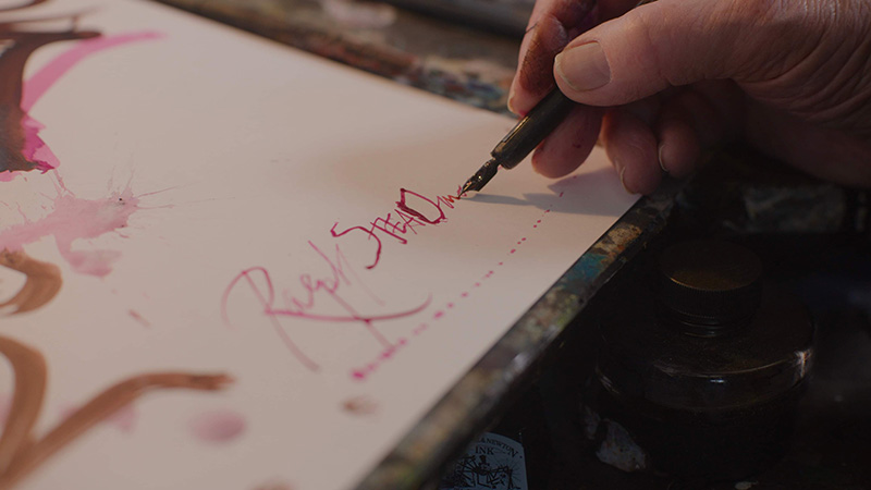 Ralph signing a painting he just made