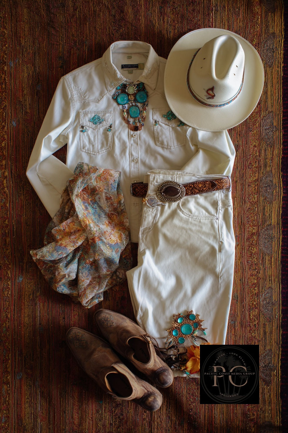 Cowboy outfit with white shirt, jeans, and hat, turquoise jewelry, patterned scarf, and brown boots on a textured rug. Logo in the corner.