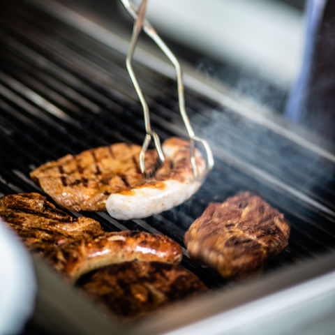 Grillen: Würstchen und Steaks auf dem Grillrost