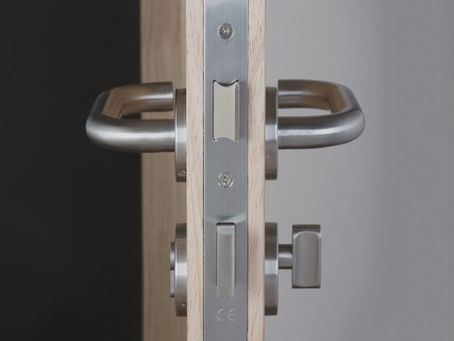 Steel lever handles and door locks mounted on a timber fire door